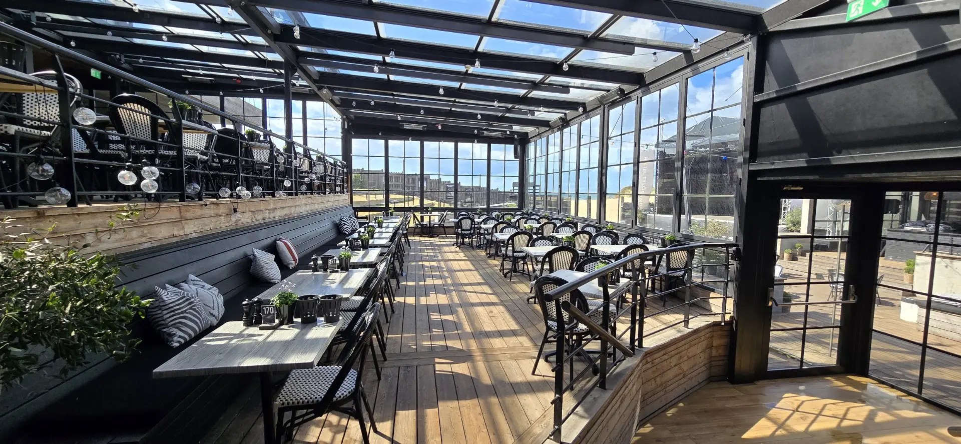 Ljus restaurangterrass med glasväggar mot havet på Hotel Tylösand